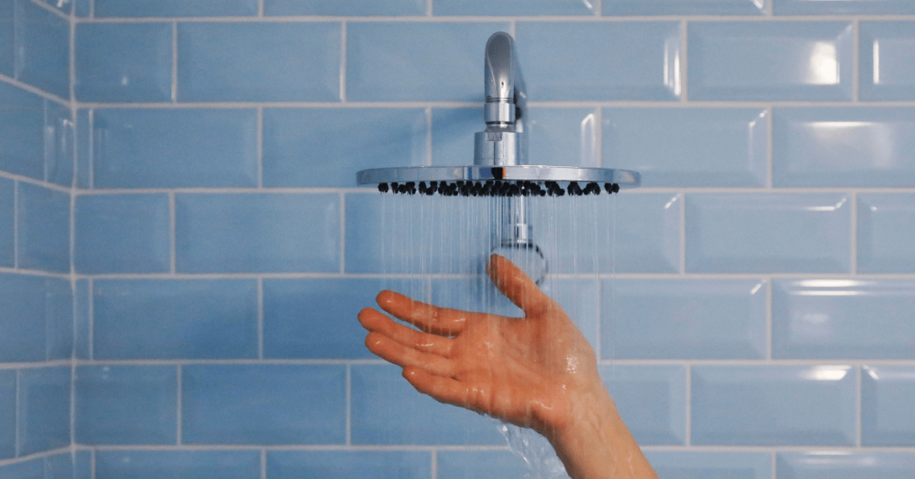 running shower with a person's hand under it
